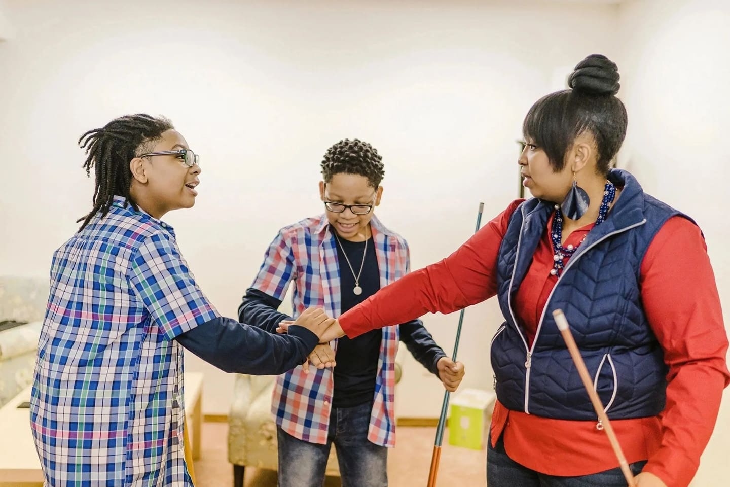 Three women shaking hands in a room.