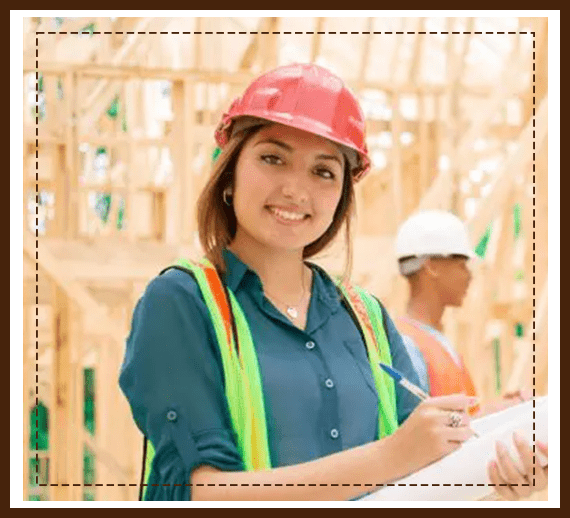 A woman in hard hat and vest holding papers.